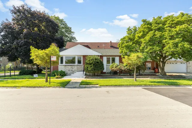 an aerial view of residential houses with outdoor space and trees