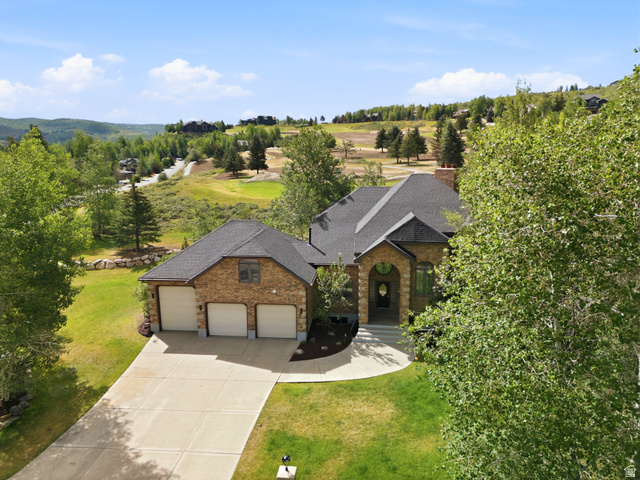 3535 Homestead Road Park City, UT 84098 - Photo 3 of 81 Stone and stucco home featuring a three-car garage, dark shingle roof, arched entryway, and mature landscaping