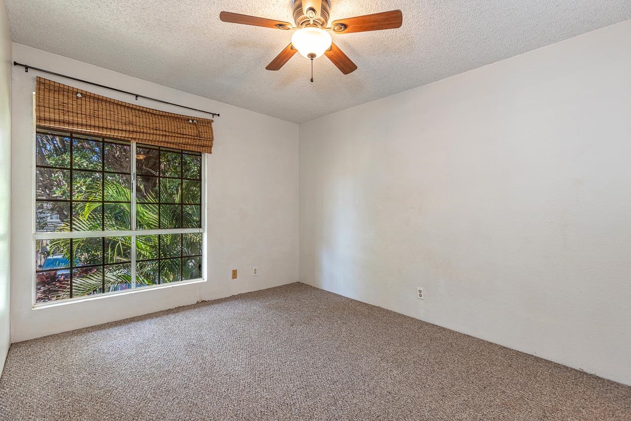 140 Uwapo Road, Unit 24202 Kihei, HI 96753 - Photo 22 of 45 a view of an empty room with window and chandelier fan