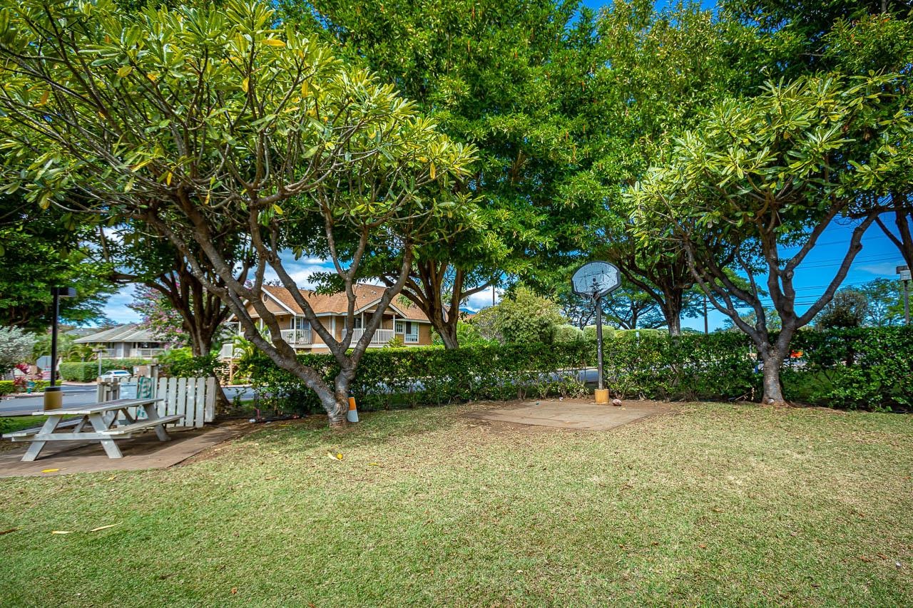 140 Uwapo Road, Unit 24202 Kihei, HI 96753 - Photo 40 of 45 a view of a backyard with table and chairs and a slide