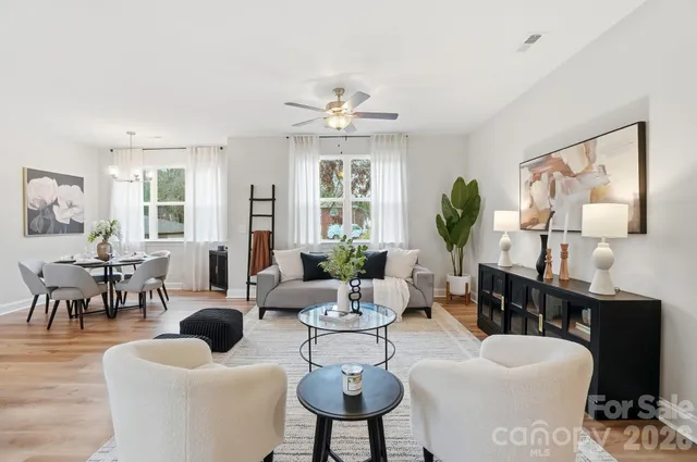 a living room with furniture a large window and a chandelier