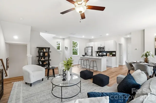 a living room with furniture kitchen and a chandelier