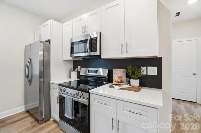 a kitchen with stainless steel appliances granite countertop a refrigerator a stove and a sink