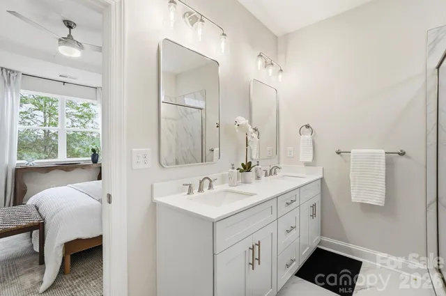 a spacious bathroom with a double vanity sink a mirror and a bathtub