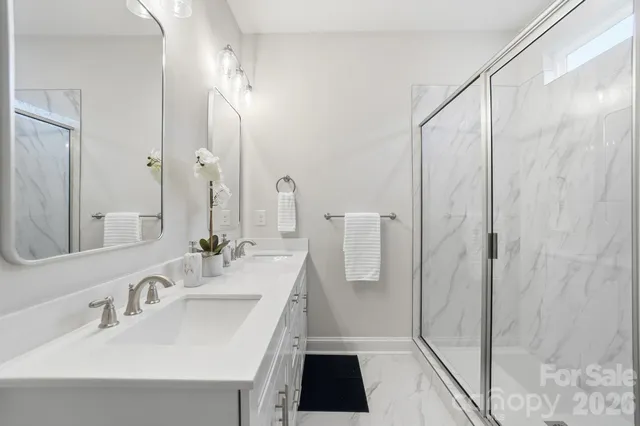 a bathroom with a sink a toilet a mirror and shower