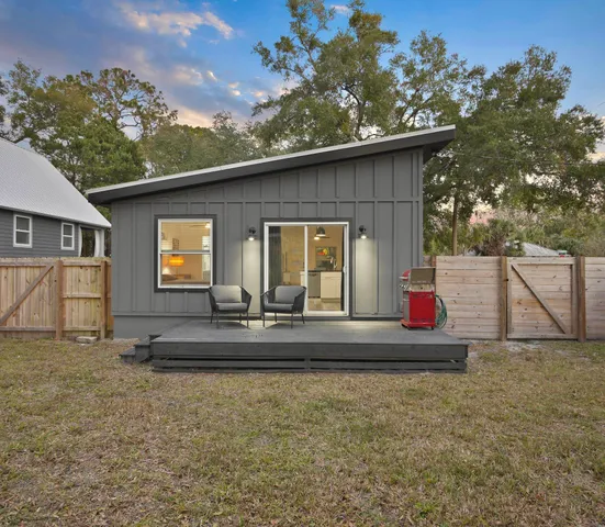 a view of a house with backyard and trees