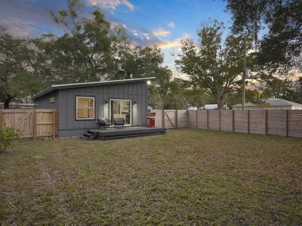 a view of a house with backyard and tree