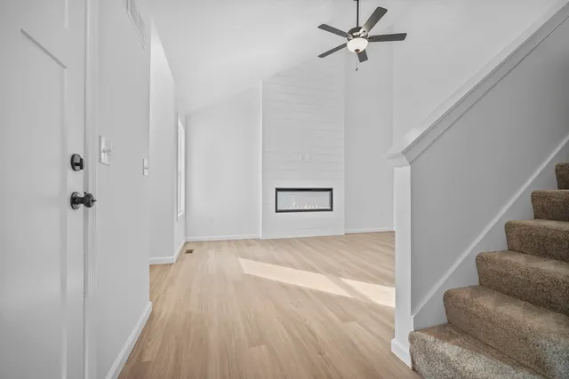 a view of a livingroom with wooden floor and a ceiling fan