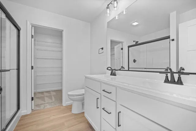 a bathroom with a double vanity sink toilet and shower