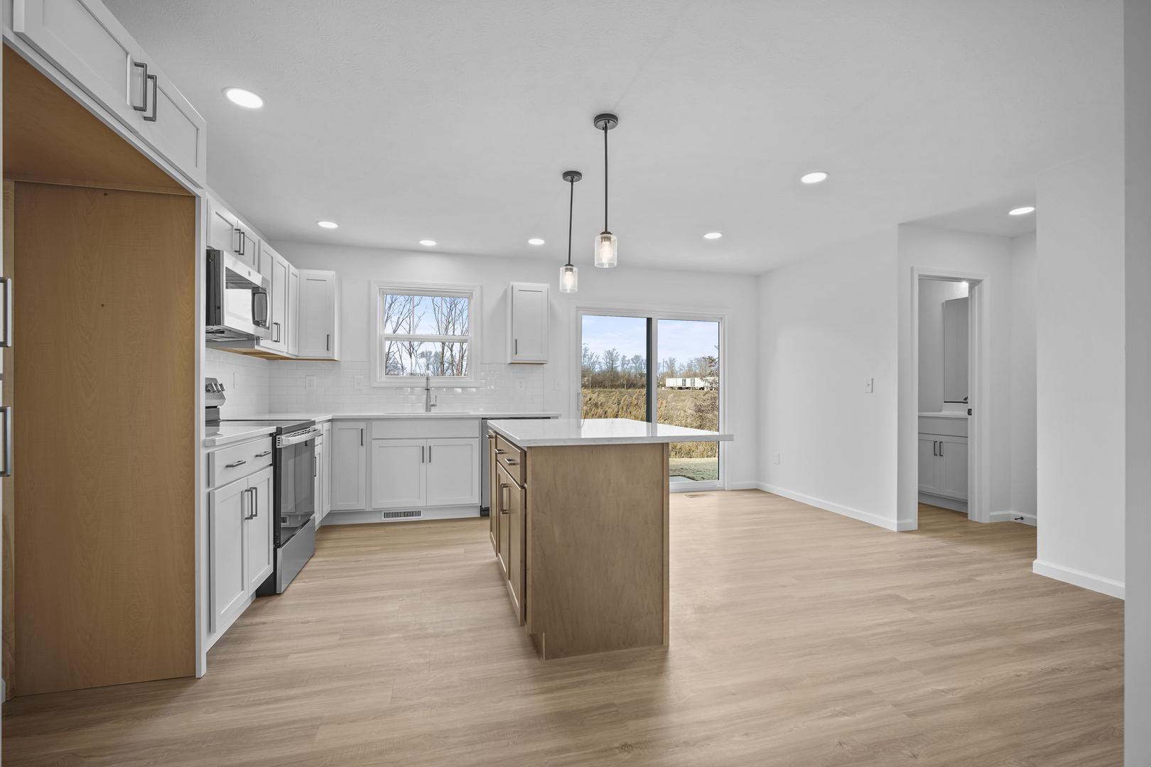 3 Eric Court Bloomington, IL 61705 - Photo 9 of 29 a large kitchen with a center island wooden floor stainless steel appliances and a window