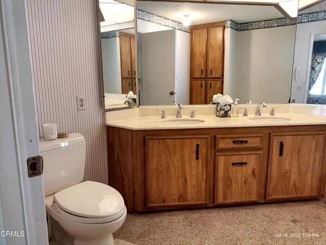 a bathroom with a granite countertop sink a toilet and a mirror