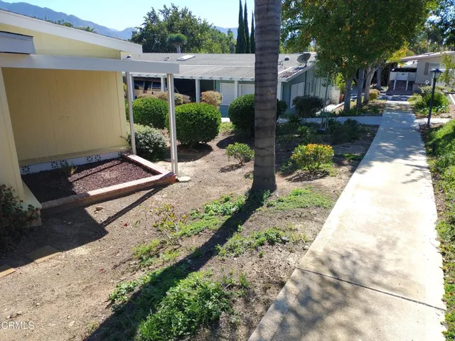 a view of a house with backyard and sitting area