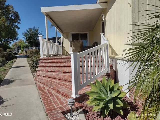 a view of a house with backyard and wooden fence