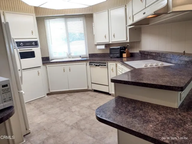 a kitchen with a stove window and cabinets
