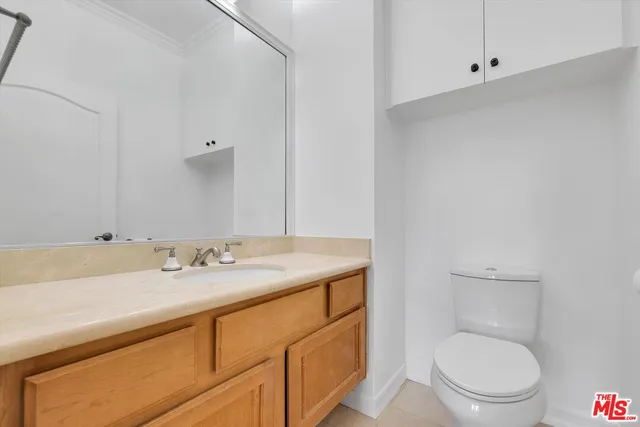 a bathroom with a granite countertop toilet sink and mirror