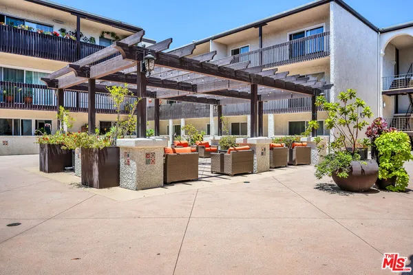 a view of a patio with table and chairs potted plants