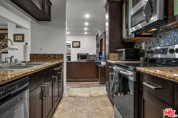 a kitchen with stainless steel appliances granite countertop a stove a sink and a refrigerator