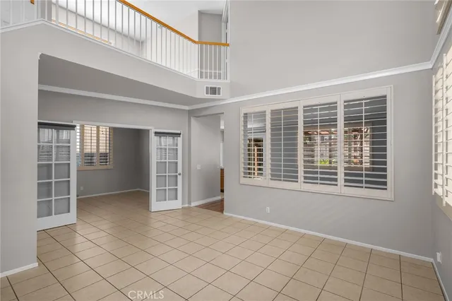 a view of an empty room with wooden floor and windows