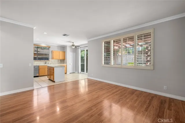 a view of empty room with wooden floor and window