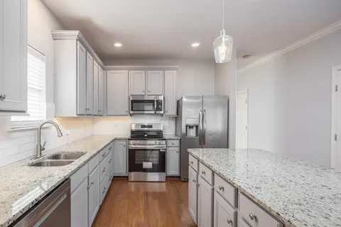 a kitchen with stainless steel appliances granite countertop a sink stove and refrigerator