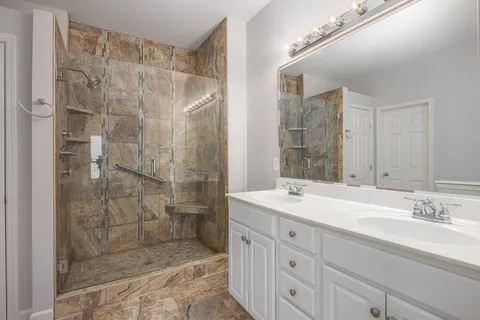 a bathroom with a shower sink and mirror