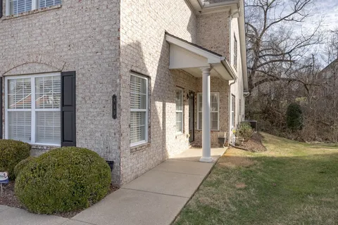 a view of a brick house with a large windows and a yard