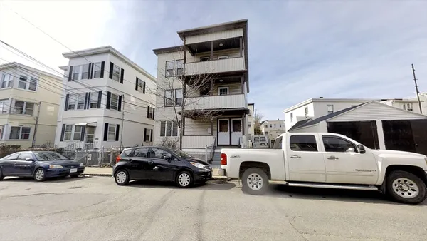 a view of a cars park in front of a building