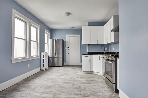 a kitchen with stainless steel appliances a refrigerator stove and cabinets
