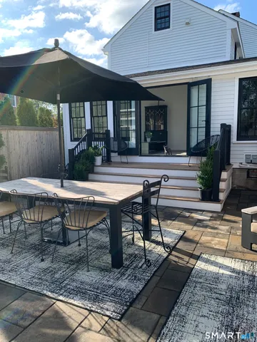 a view of a house with backyard and sitting area