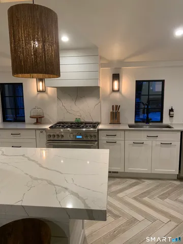 a kitchen with granite countertop a stove a sink and a microwave