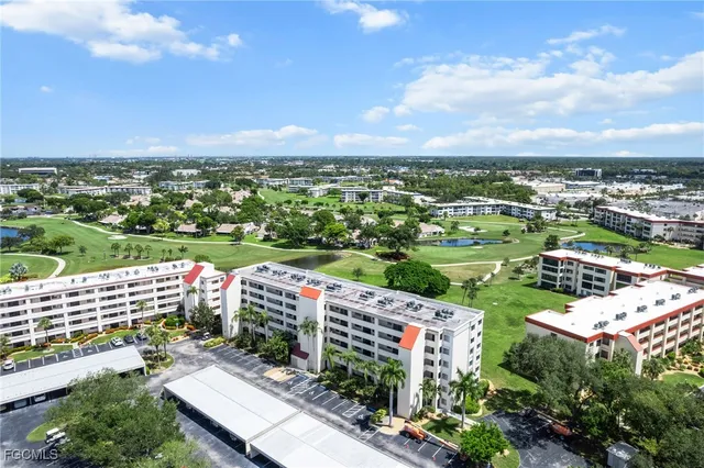 an aerial view of a city with lots of residential buildings ocean and mountain view in back