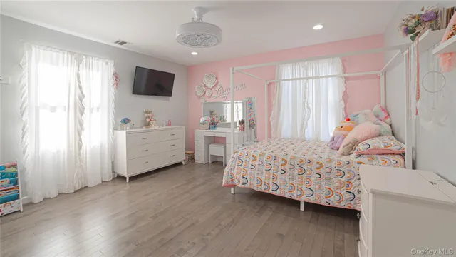 a bedroom with a large bed and wooden floor