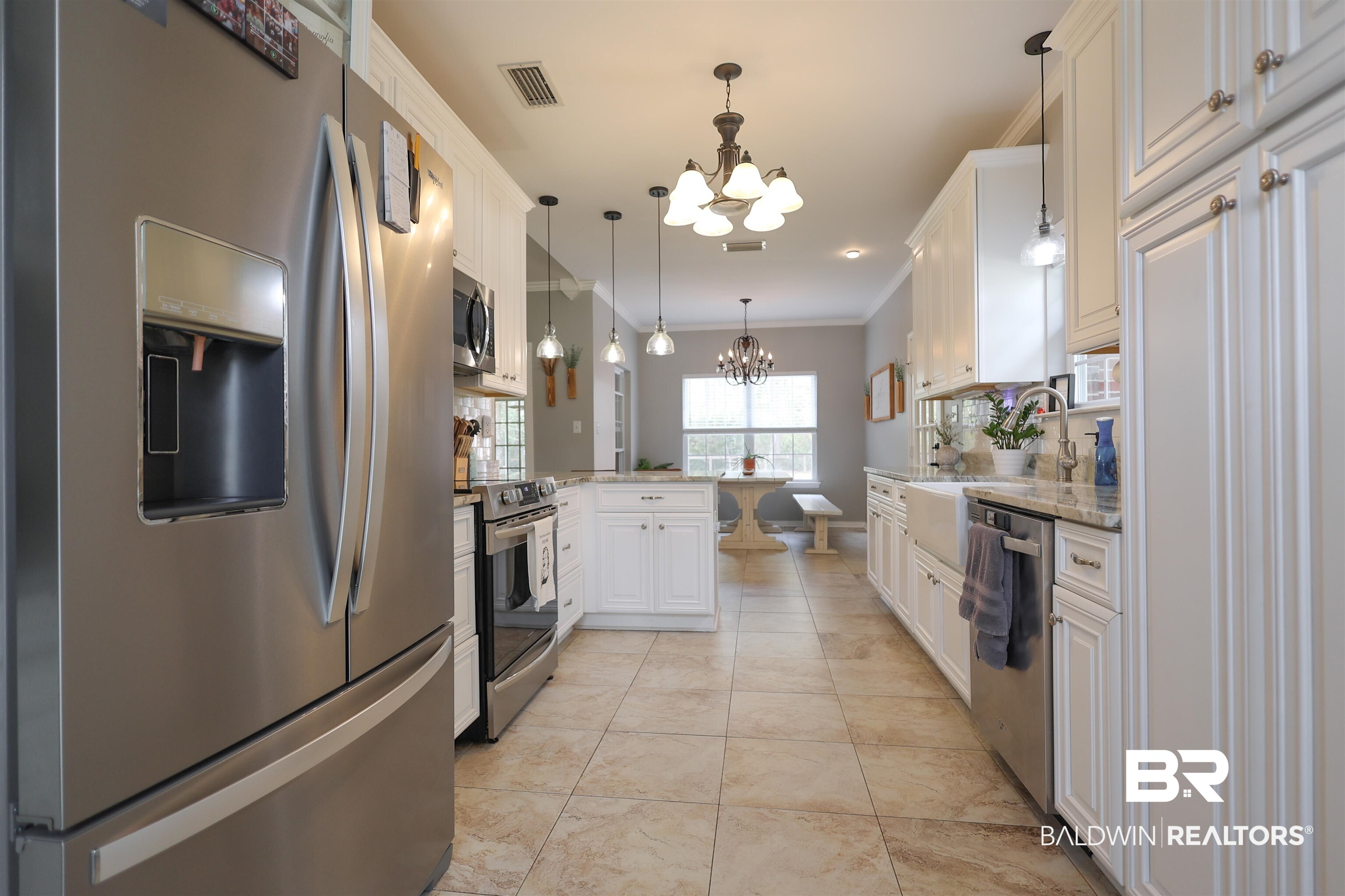 5151 Beatrice Road Gulf Shores, AL 36542 - Photo 15 of 50 Kitchen featuring stainless steel appliances, suspended lighting, ornamental molding, a peninsula, and white cabinets