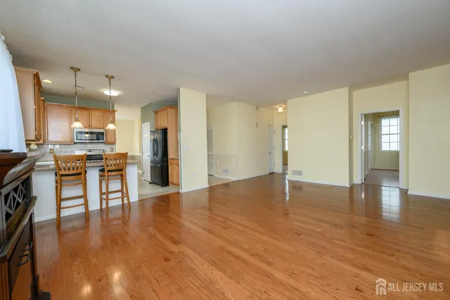 a view of a kitchen with a sink a refrigerator and chairs