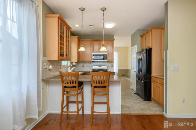a kitchen with a table chairs refrigerator and microwave