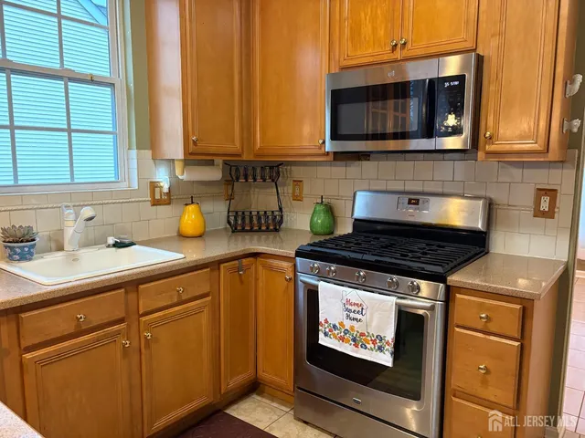 a kitchen with stainless steel appliances a stove a sink and a microwave