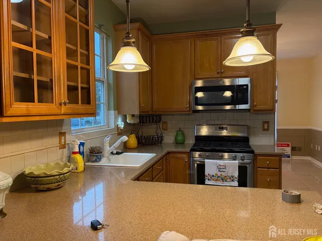a kitchen with stainless steel appliances granite countertop a sink a stove and a microwave