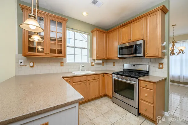 a kitchen with stainless steel appliances granite countertop a stove a sink and a microwave