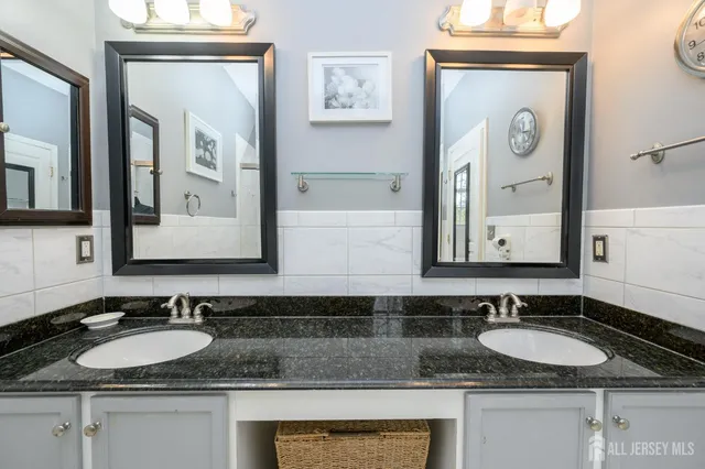 a bathroom with a granite countertop sink and a mirror