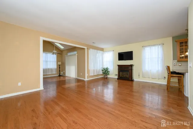 a view of a livingroom with wooden floor and a fireplace