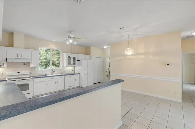 a view of a big room with chandelier front door and mountain view