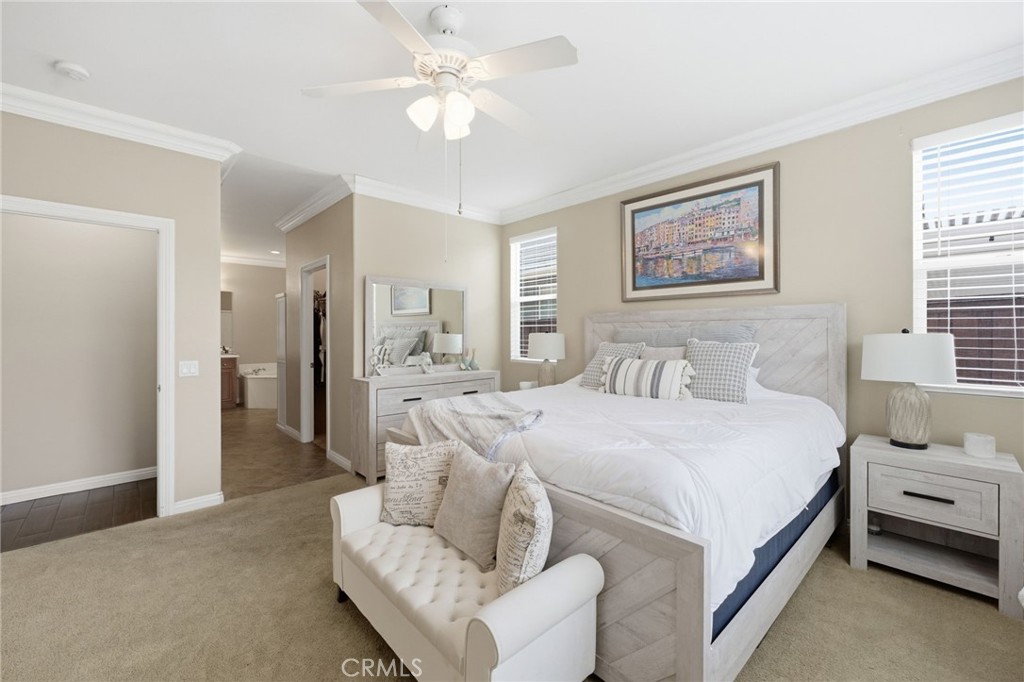7975 Doyle Circle Hemet, CA 92545 - Photo 15 of 29 a spacious bedroom with a bed and a chandelier