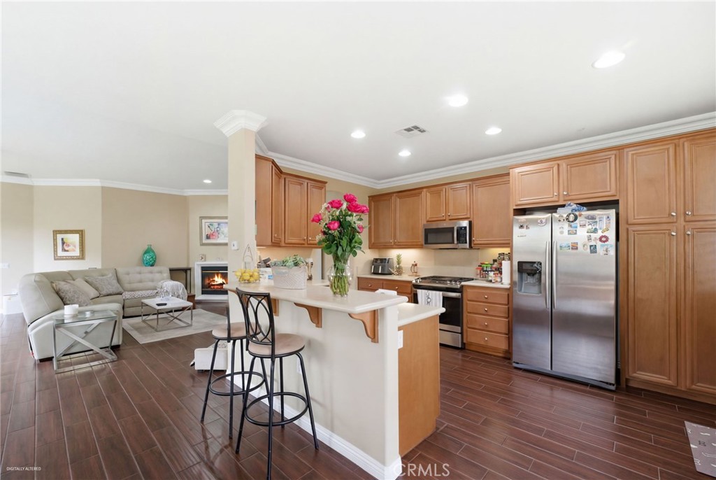 7975 Doyle Circle Hemet, CA 92545 - Photo 9 of 29 a kitchen with a table chairs refrigerator and cabinets