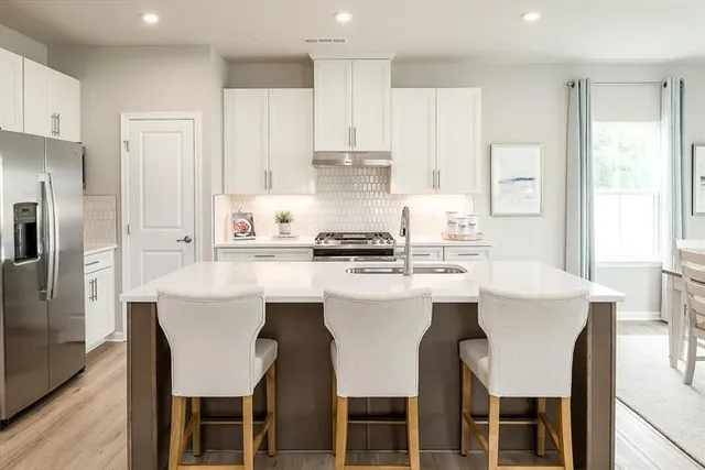 a kitchen with stainless steel appliances a white stove top oven and refrigerator
