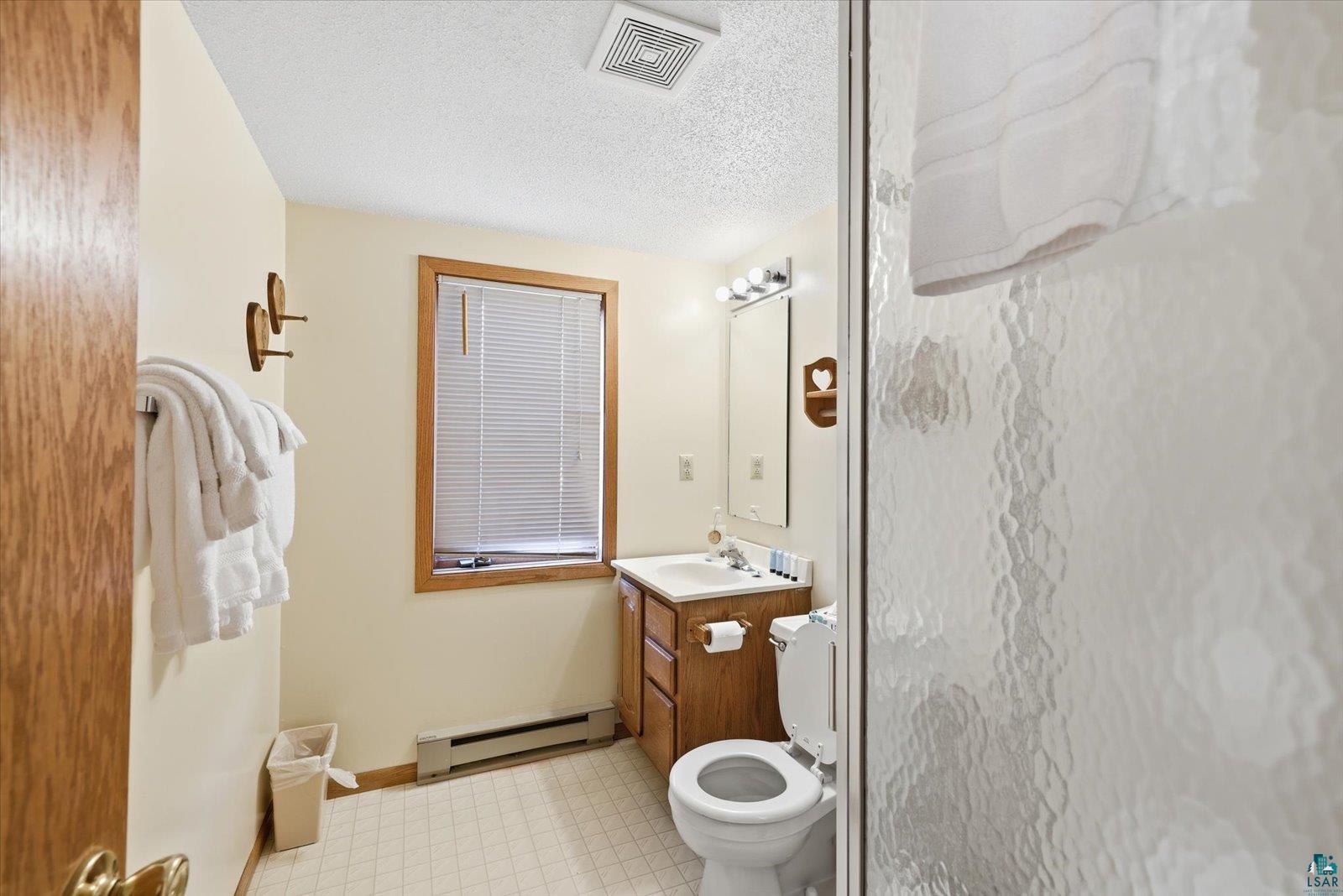 6266 Giants Ridge Road Biwabik, MN 55705 - Photo 27 of 29 Bathroom featuring wood-finish vanity, white countertop, and tiled flooring