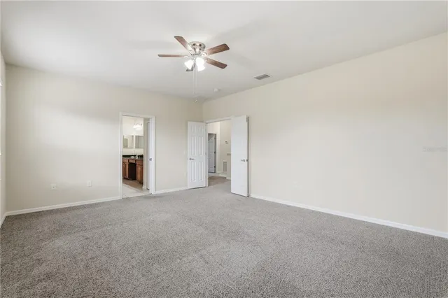 an empty room with closet and windows