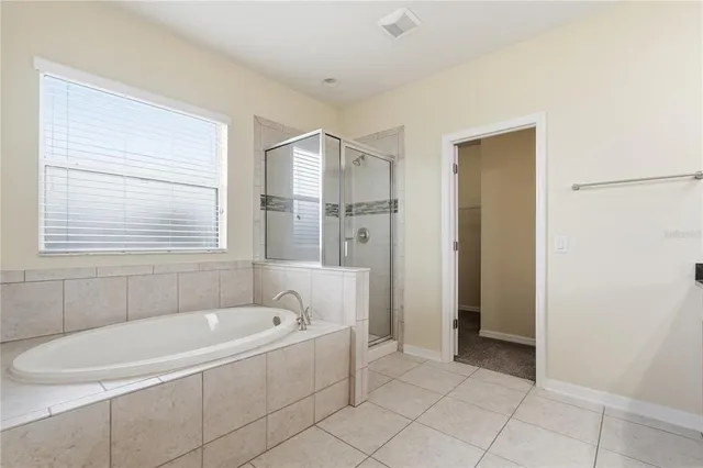 a white bath tub sitting in a bathroom next to a window