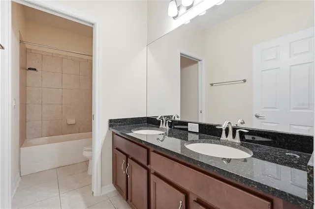 a bathroom with a granite countertop sink and a bathtub