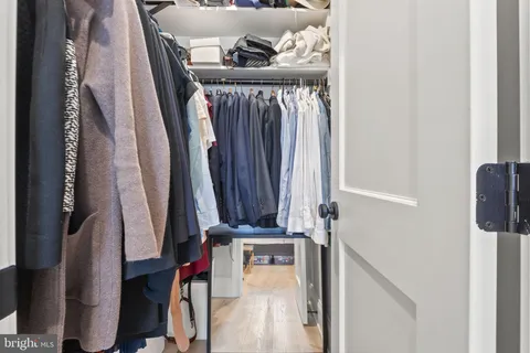 a view of walk in closet with clothes and shoes