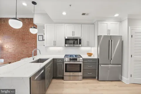 a kitchen with stainless steel appliances granite countertop a stove a refrigerator and a sink